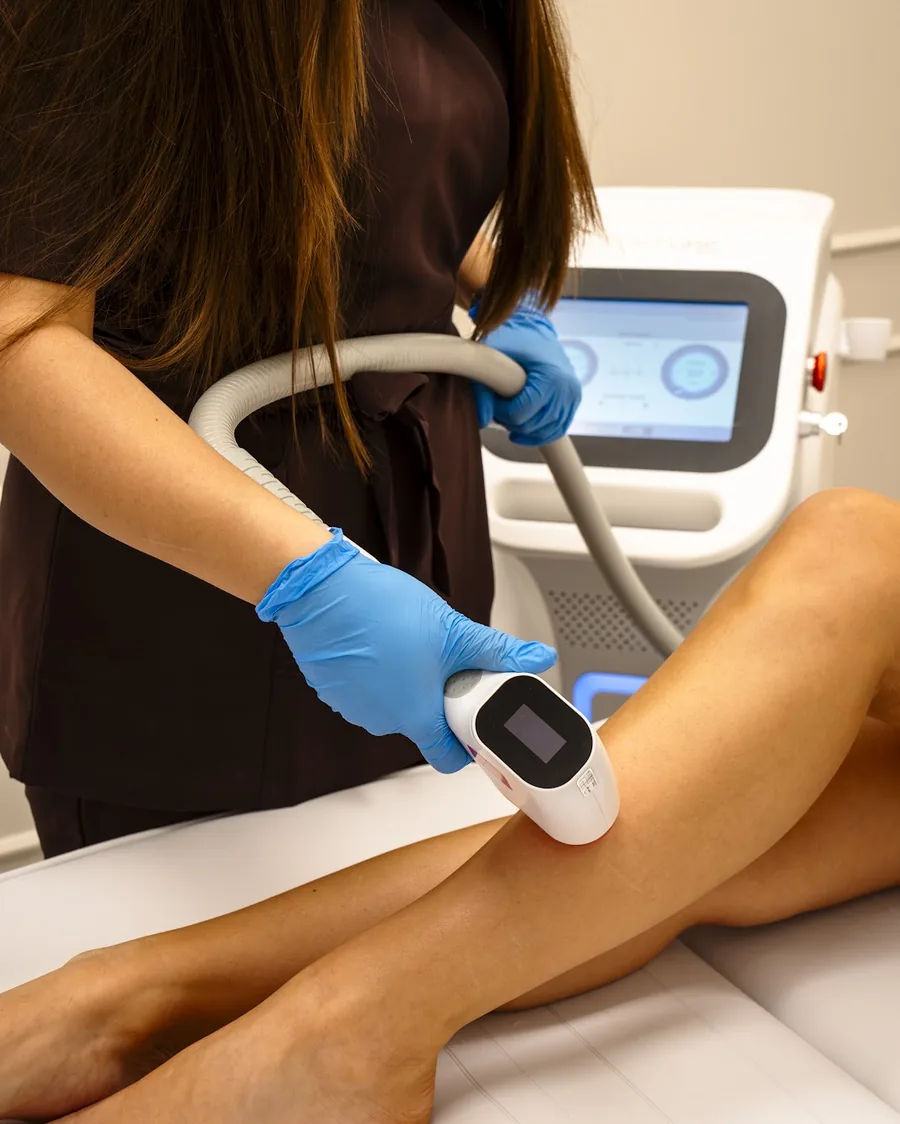 Depilacja laserowa nogi w salonie LUMI LAB: kosmetolożka prowadzi głowicę lasera diodowego